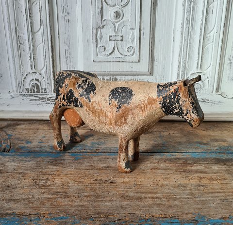 Old wooden toy in the form of a large black-colored wooden cow