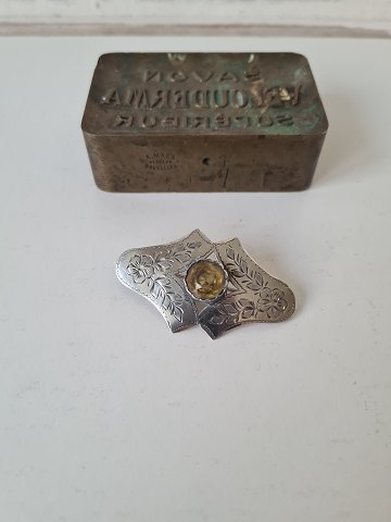 Old silver brooch with large yellow stone