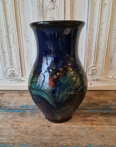 Danico large midnight blue vase decorated with green leaves and red berries 28 
cm.