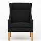 Børge Mogensen / Fredericia Furniture
BM 2204 - Nybetrukket Øreklapstol i mørkegrå Hallingdal 65-uld (farve 180) med 
ben i eg.
Øreklapstolen (1963) omslutter den siddende med fokus på komforten. Stolen fås 
i flere varianter.
Leveringstid: 6-8 uger
Ny-restaureret

