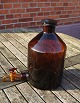 Large and well-maintained 5 liter apothecary bottle with pouring spoutin in dark 
brown glass. On the back there are liter measurements.